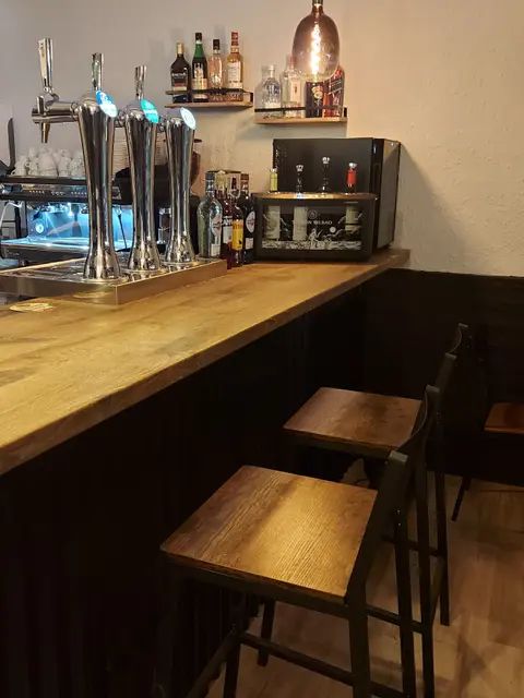La barra de madera con los grifos de cerveza y taburetes altos