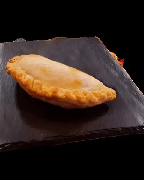 Una empanada recién hecha sobre una pizarra negra
